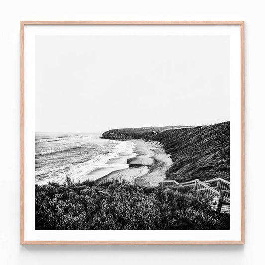 A black and white framed photography print of a coastal ocean scene at Bells beach and surf, looking towards a headland.