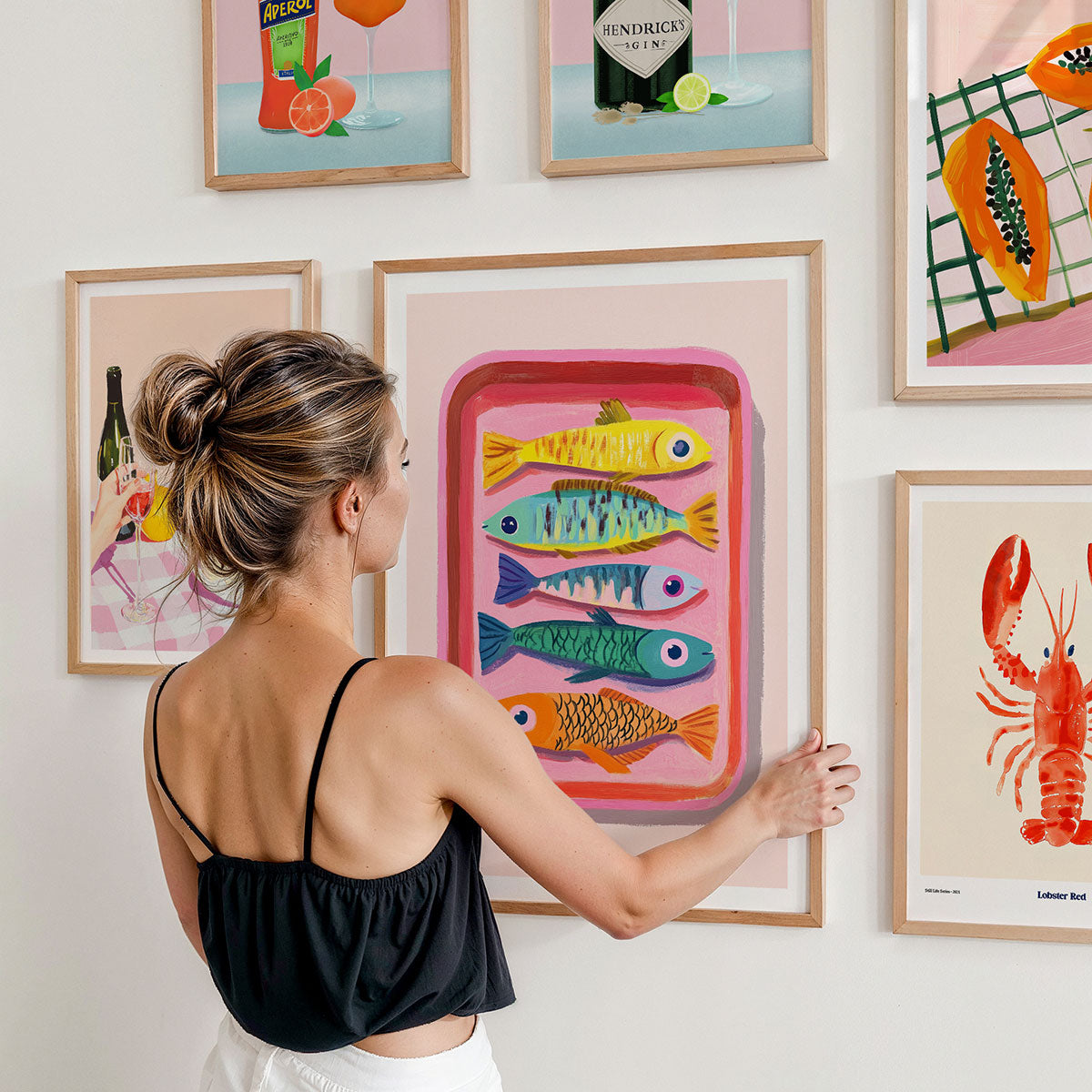 A gallery wall of framed art prints featuring food and drink themed art