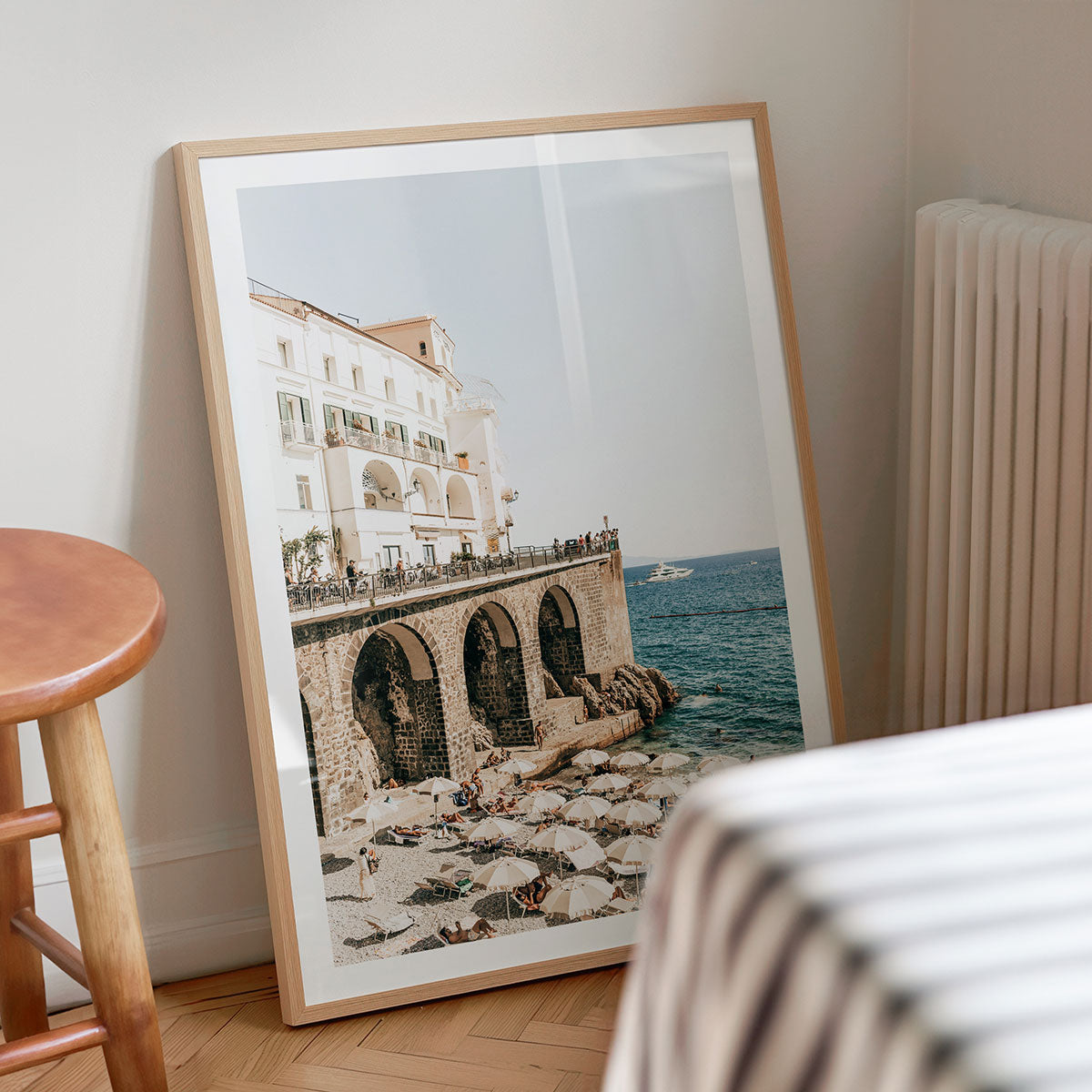 Framed photography print of a Amalfi Coast scene with buildings and ocean on a wall.