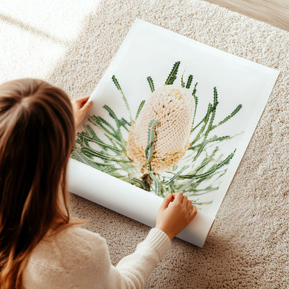 Woman unrolling a poster print with a floral photography on a carpeted floor.