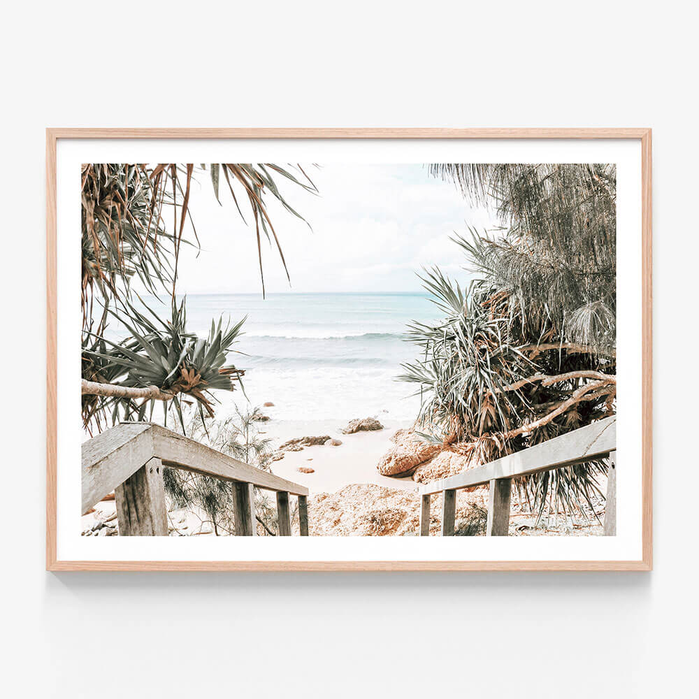 A coastal framed print featuring a path leading to the beach with pandanus palm trees and the ocean