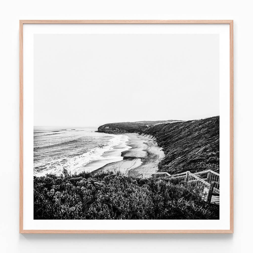 A black and white framed photography print of a coastal ocean scene at Bells beach and surf, looking towards a headland.