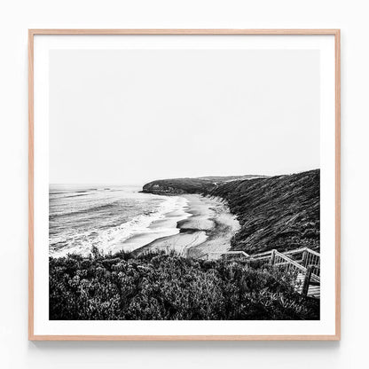 A black and white framed photography print of a coastal ocean scene at Bells beach and surf, looking towards a headland.