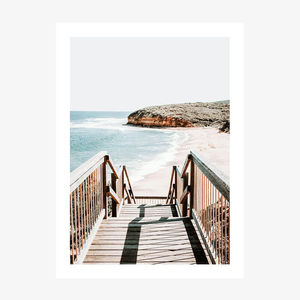 A photo poster print of a staircase leading down to Bells beach with the ocean and a headland in the background.