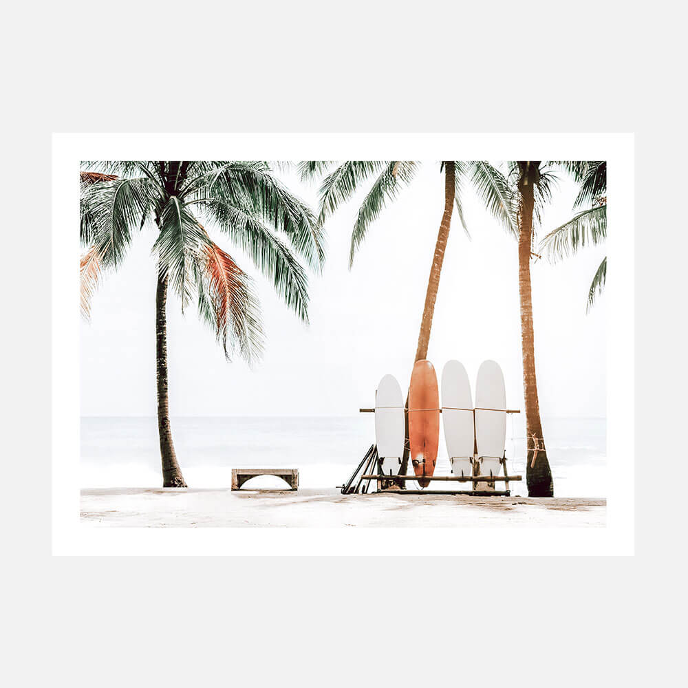 A photo art print featuring multiple surfboards leaning against a beach chair with palm trees in the background.