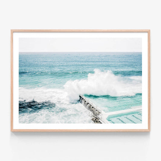 A framed print featuring an Australian coastal scene with a large wave crashing in the ocean at Bondi Beach.