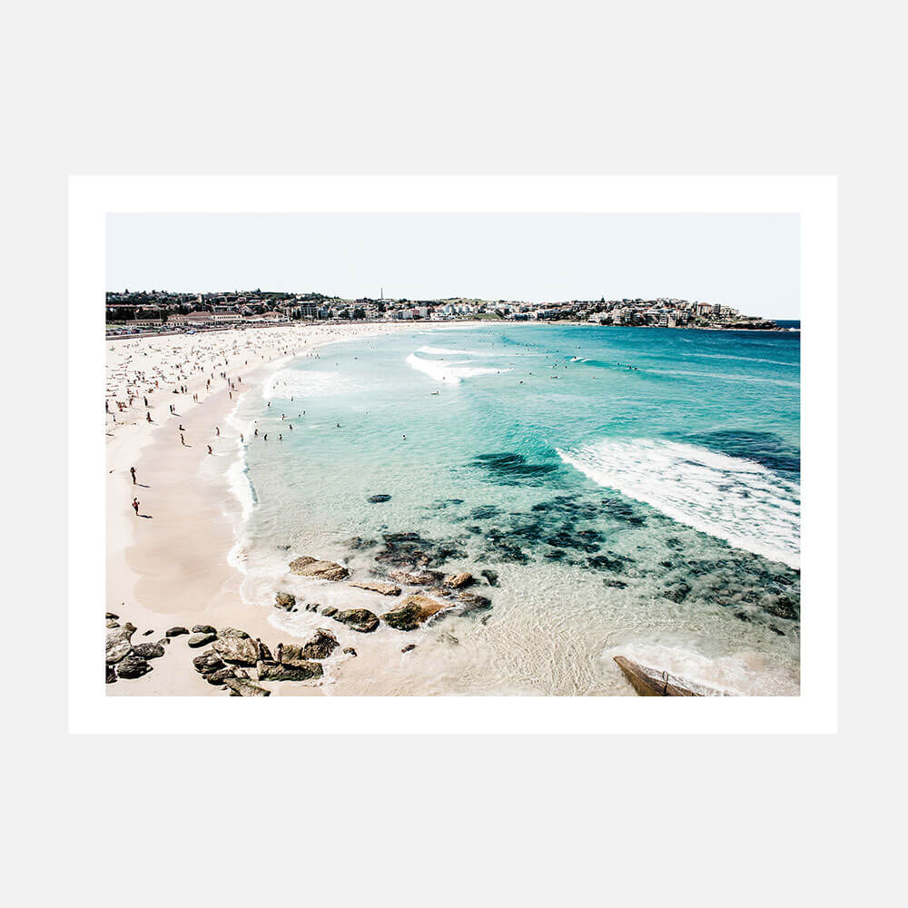 A wall art print of Bondi Beach with clear blue water, sand, and a coastal landscape.