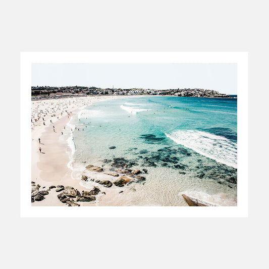 A wall art print of Bondi Beach with clear blue water, sand, and a coastal landscape.