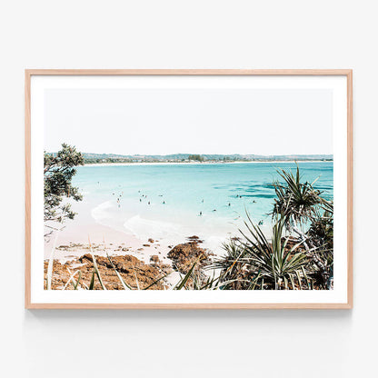 A framed art print featuring a photo of the beach at Byron Bay