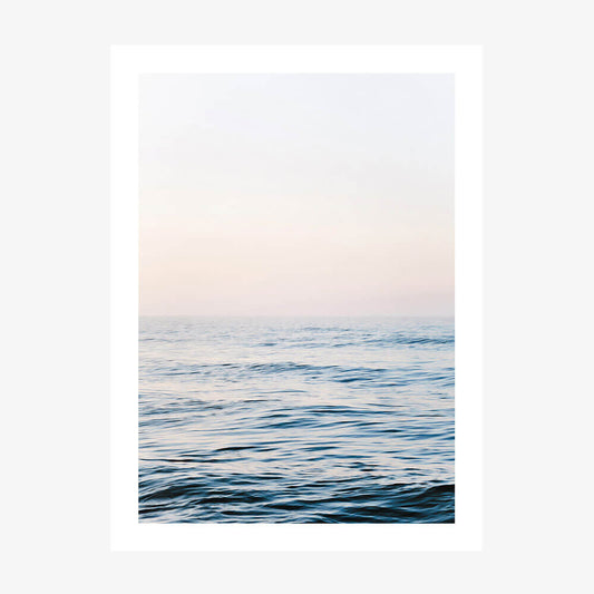 A framed picture of a calm ocean with a minimalist design, featuring gentle waves and a soft blue color palette.