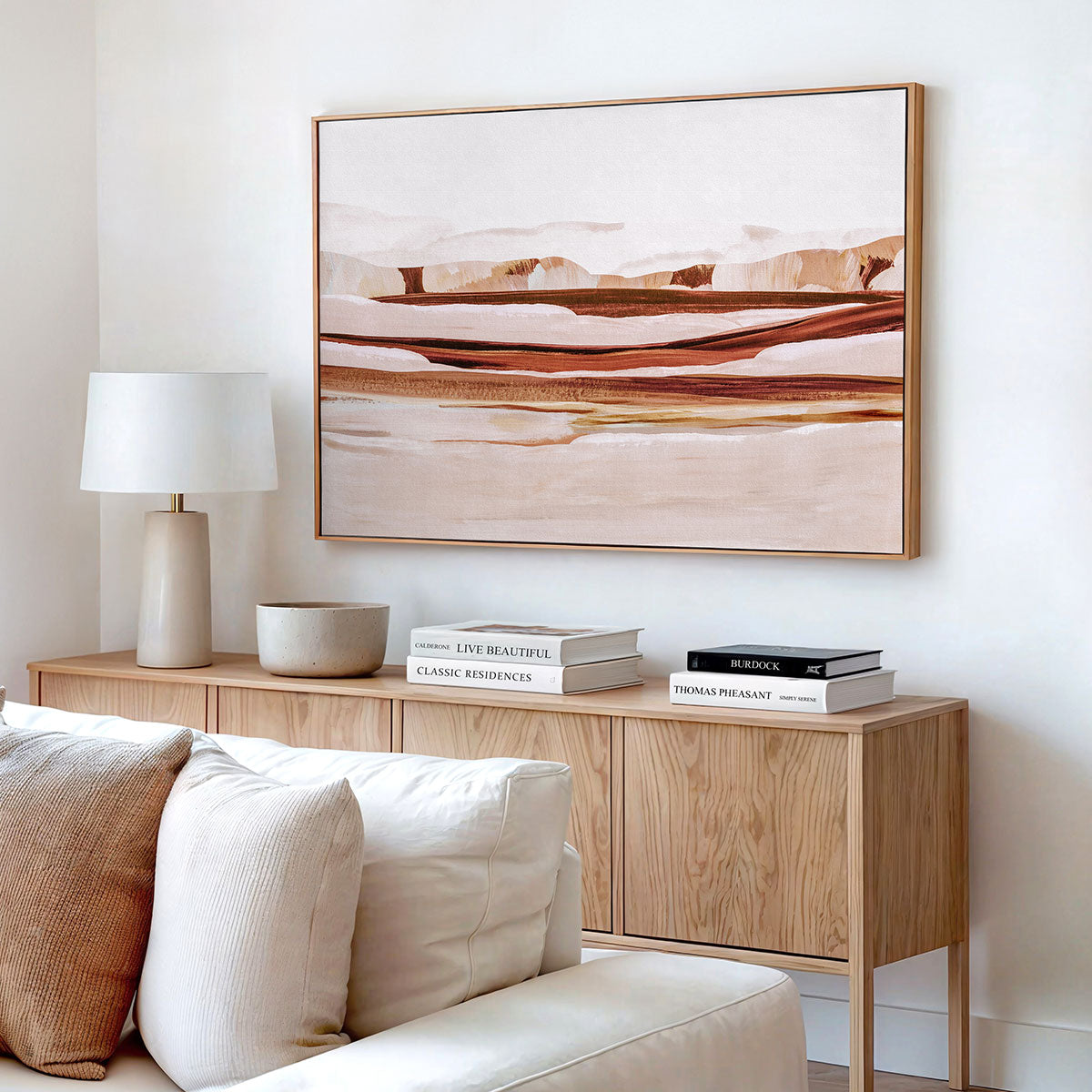 Modern living room with a framed canvas artwork on the wall, sofa, and timber sideboard.