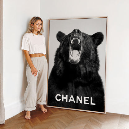 Woman standing next to a large framed canvas print of a bear with 'Chanel' fashion branding.