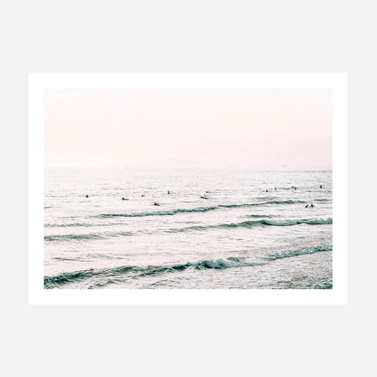 A poster print with a coastal surfboard theme, featuring a body of water with gentle waves and individuals on surfboards.