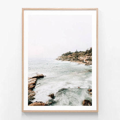 A framed photo print featuring the Coogee Coast with ocean waves and a rocky shore, providing a serene view of nature.