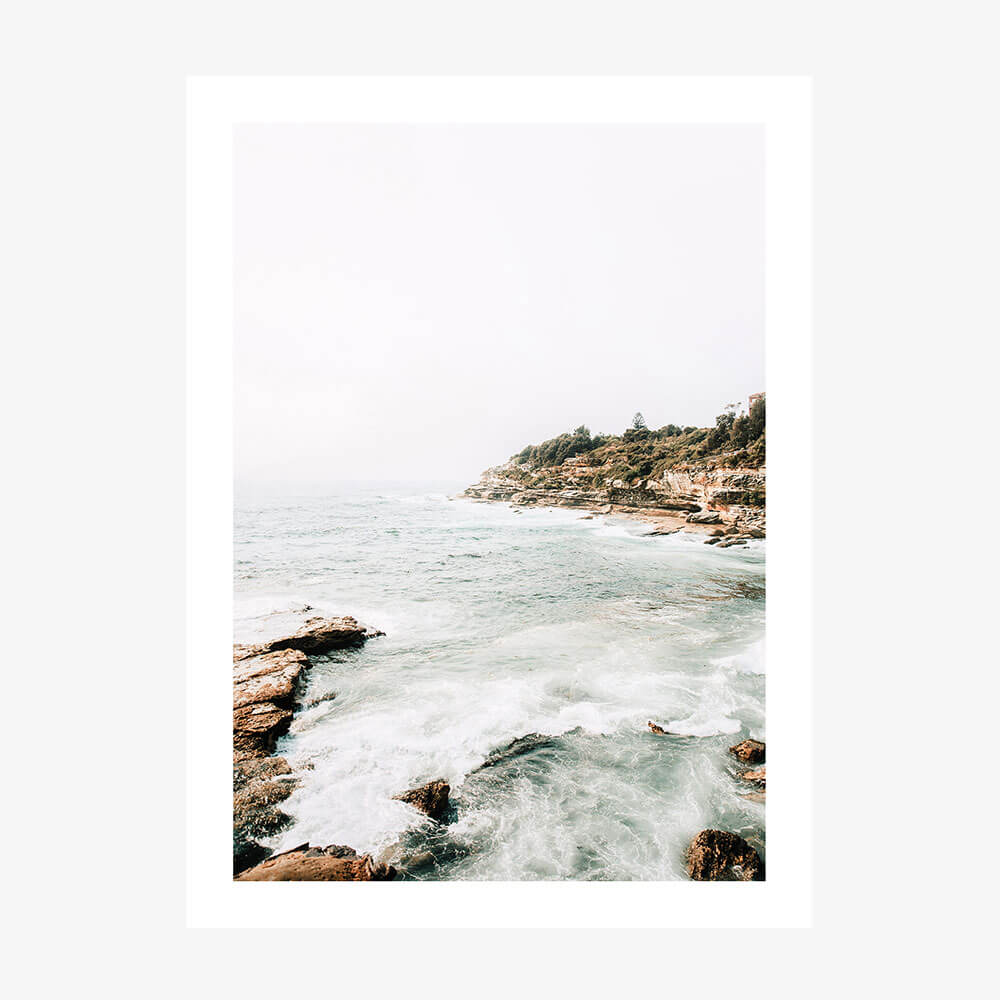 A photo print featuring the Coogee Coast with ocean waves and a rocky shore, providing a serene view of nature.