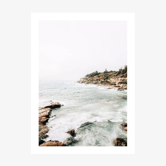 A photo print featuring the Coogee Coast with ocean waves and a rocky shore, providing a serene view of nature.
