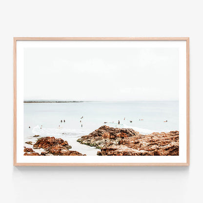 A framed coastal art print featuring surfers at the Pass in Byron Bay.