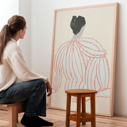 Woman sitting on a stool looking at a large framed abstract artwork in a minimalistic room.