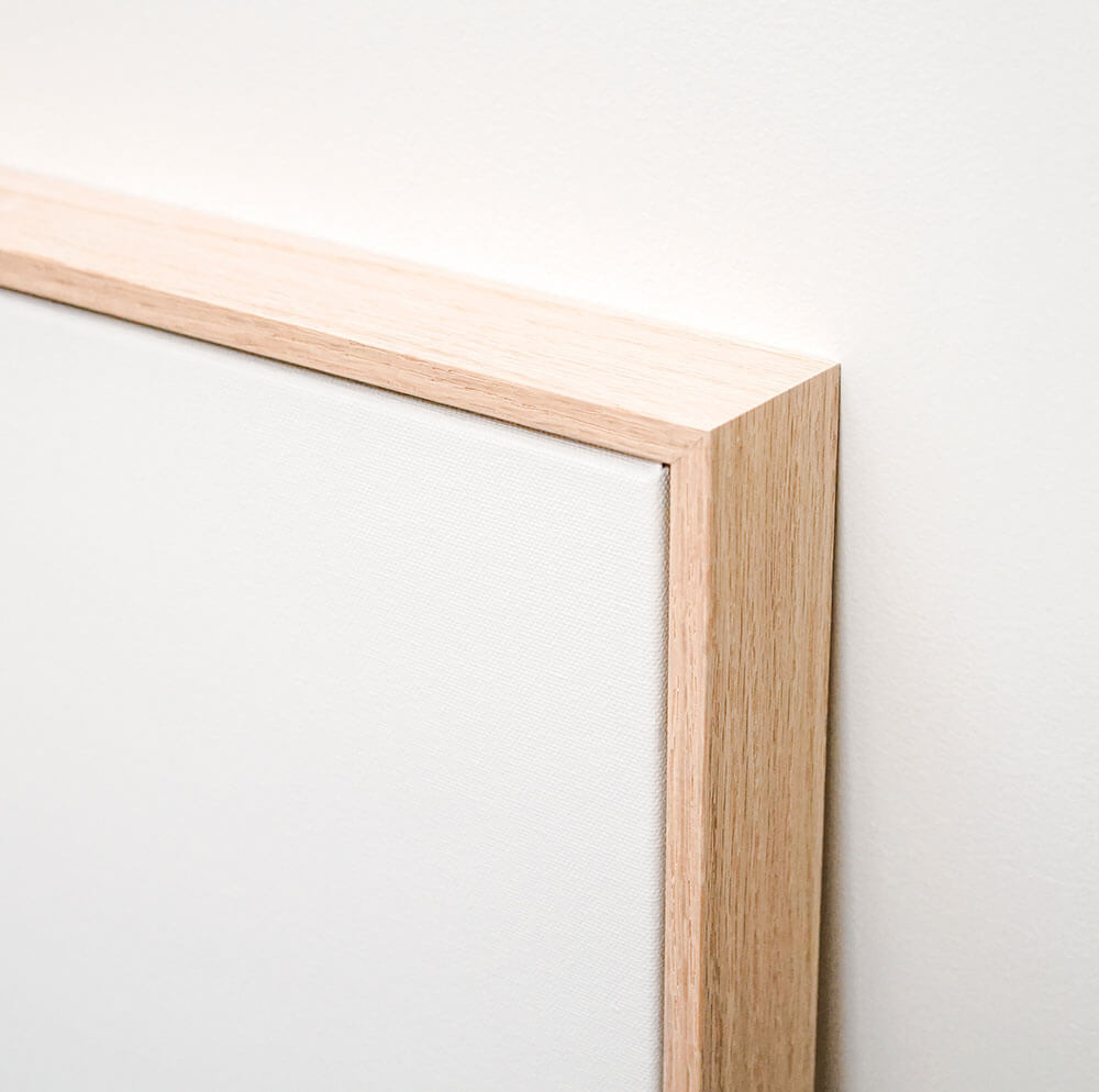 A close up of the oak float frame around a canvas wall art print.