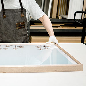 Close up of Tom assembling a framed print in the Geelong factory.