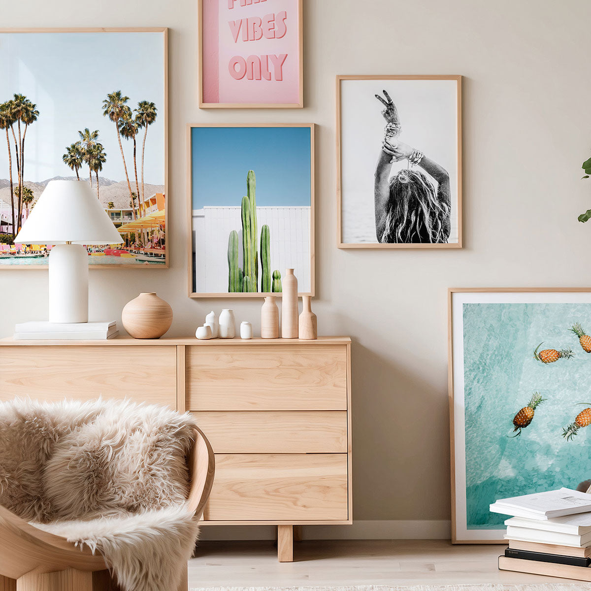 Modern living room with wooden dresser, decorative wall art items, and framed artwork on a beige wall.