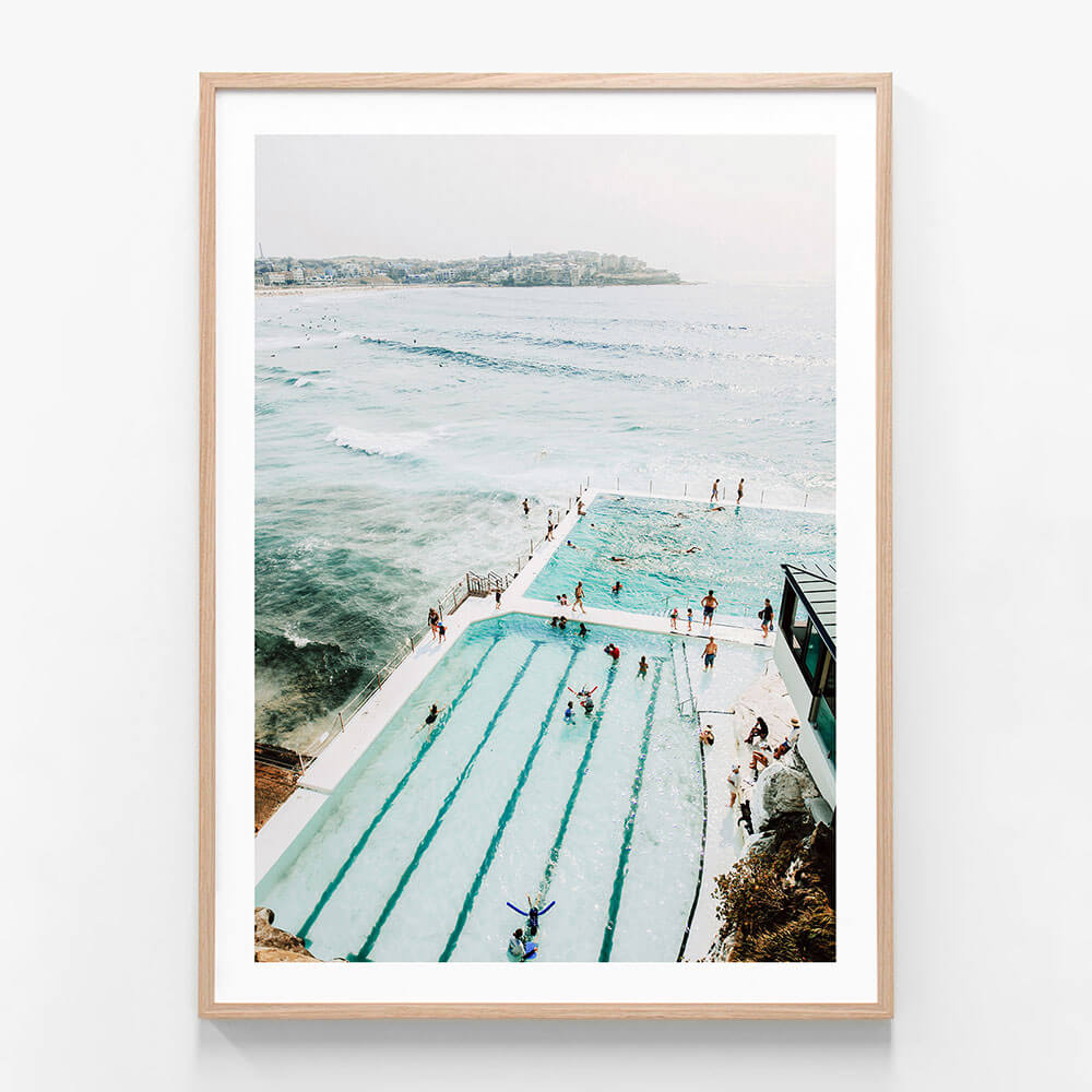 A print of the icebergs pool at Bondi Beach with a view of the ocean, featuring people swimming and enjoying the water.