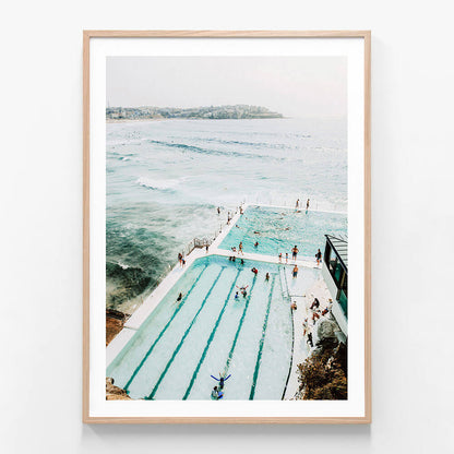 A print of the icebergs pool at Bondi Beach with a view of the ocean, featuring people swimming and enjoying the water.