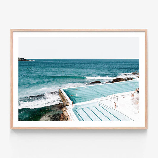 A framed print of a coastal ocean scene with the Bondi icebergs pool in the foreground and the sea in the background.