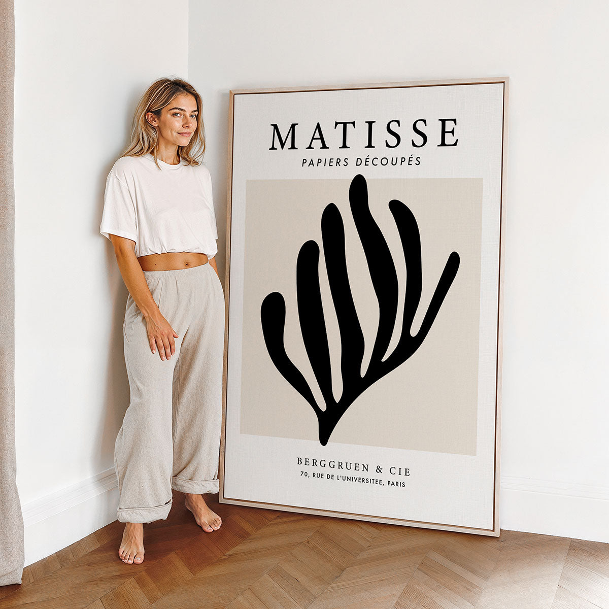Woman standing next to a large Matisse canvas art print in a minimalistic room.