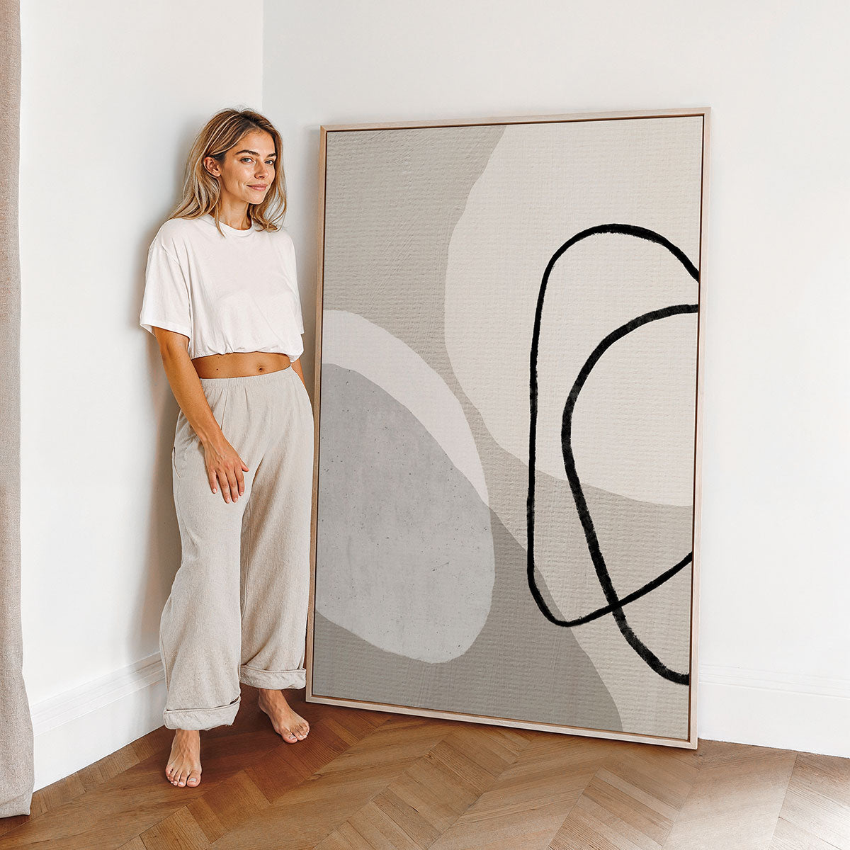 Woman standing next to a large canvas abstract art print in a minimalistic room.