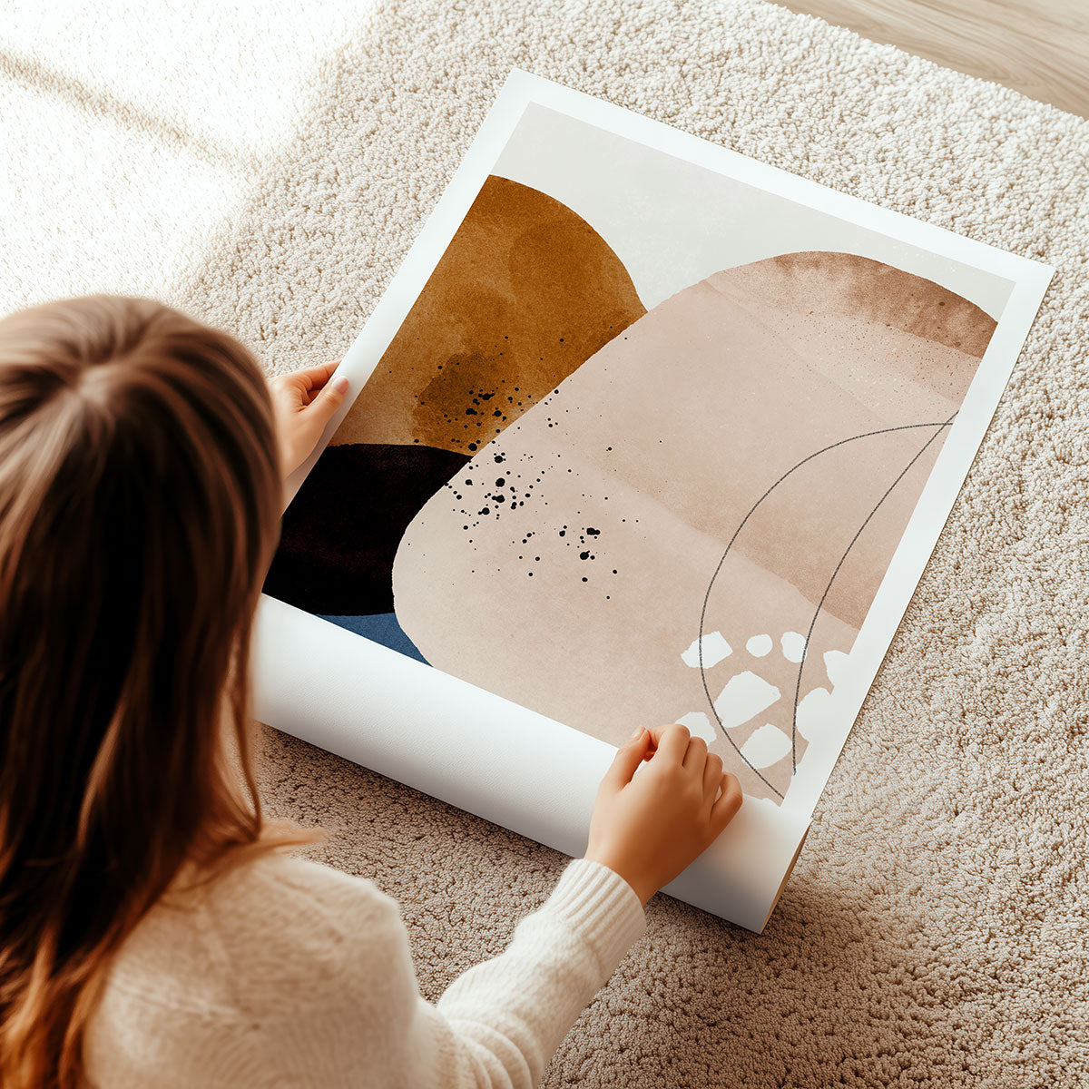 A woman unrolling a large abstract art print with a minimalist style.