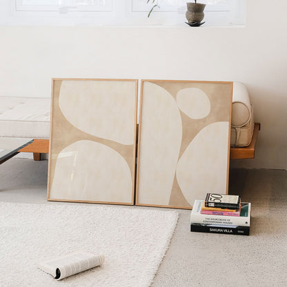Abstract framed wall art prints with large beige circles in a minimalistic living room.