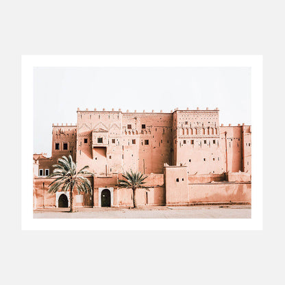 A photo art print of a Moroccan kasbah with adobe walls and several gates or openings, surrounded by palm trees.
