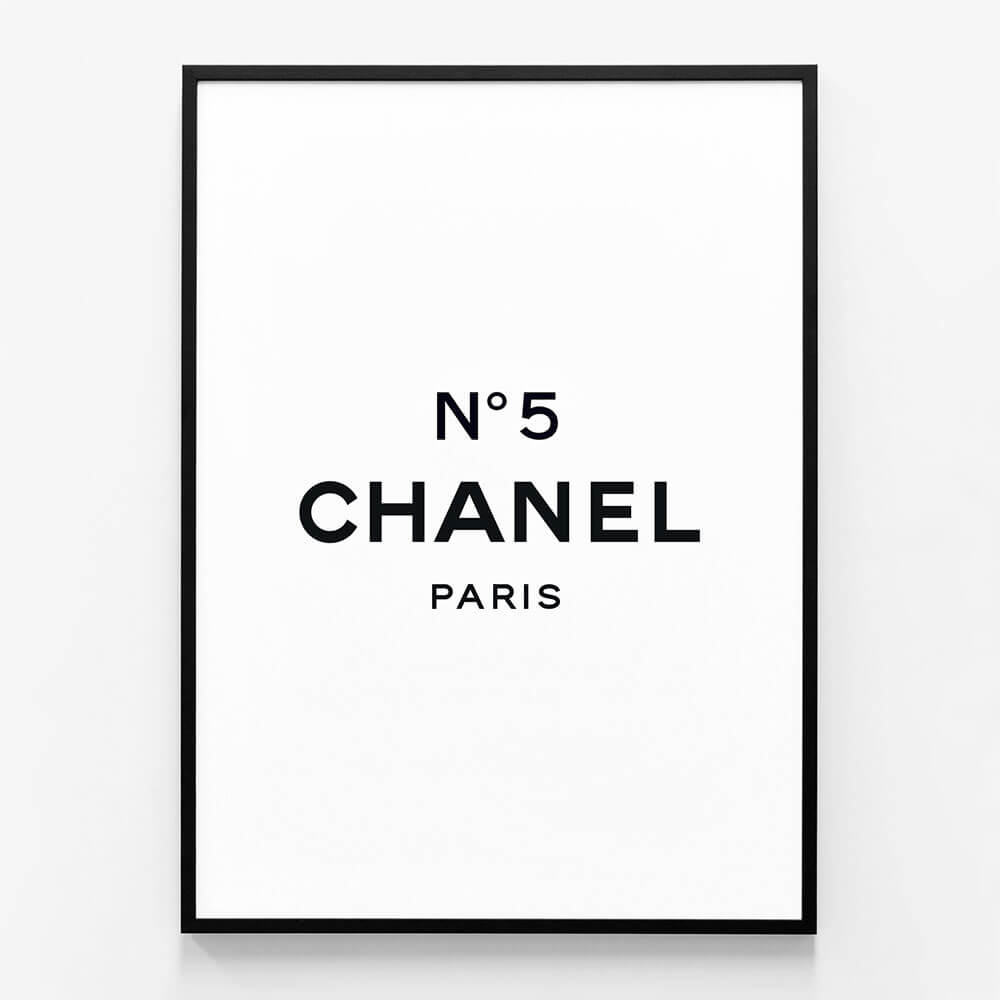 A framed art poster of Chanel No 5 with a black frame