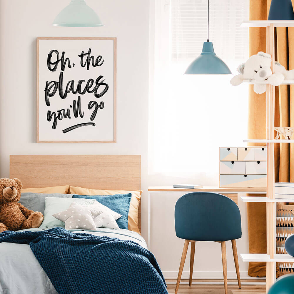 Children's bedroom with bed, chair, and framed poster on the wall