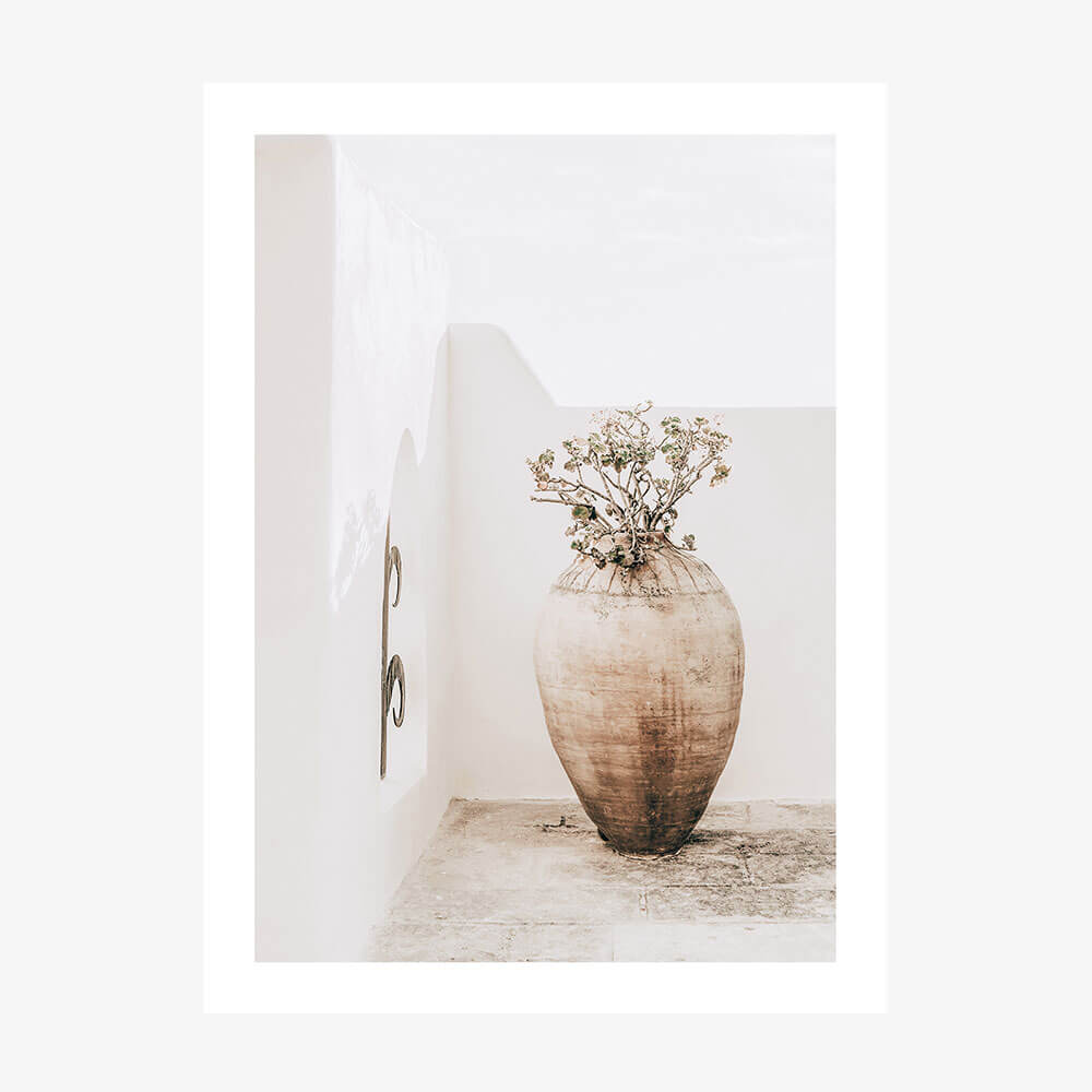 A photo wall art print featuring a large earthenware vase with a dried plant arrangement, placed against a neutral background.