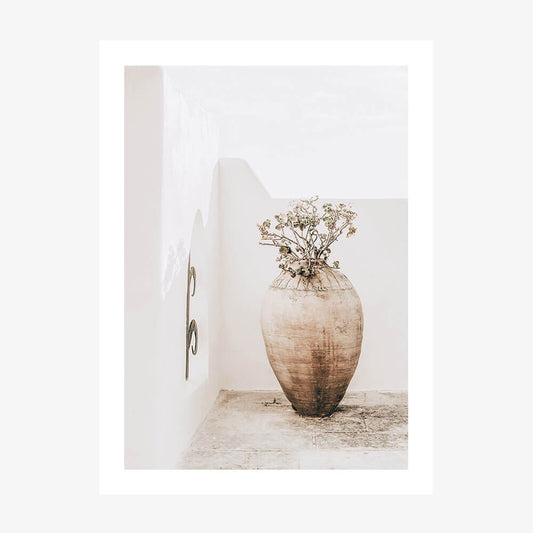 A photo wall art print featuring a large earthenware vase with a dried plant arrangement, placed against a neutral background.