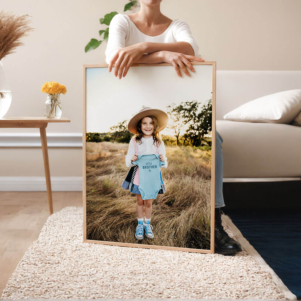 A woman holding a framed family photo.