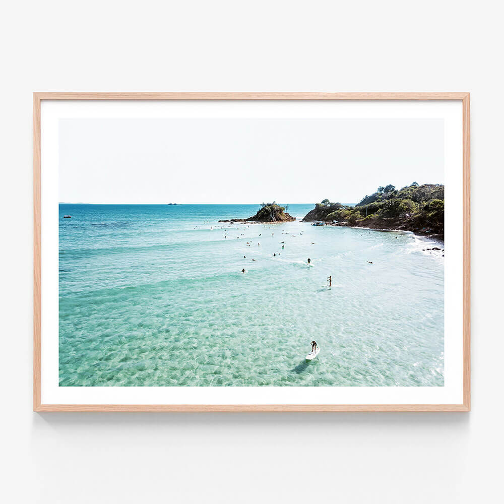 A framed photo art print featuring a coastal sen of surfers at the Pass in Byron Bay.