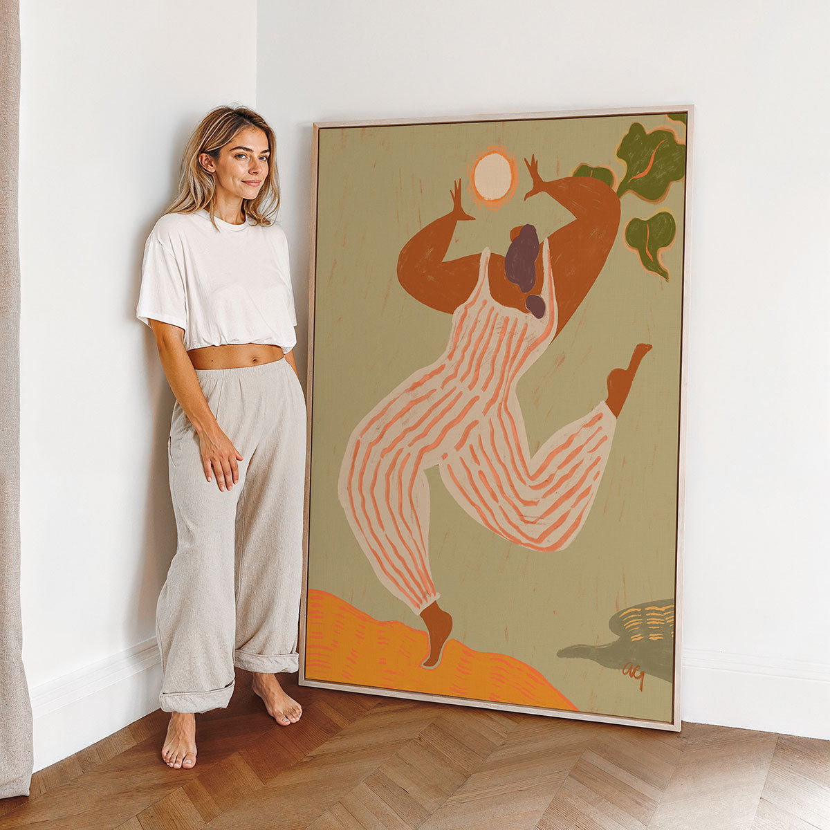 Woman standing next to a large abstract canvas art print in a room with wooden flooring.