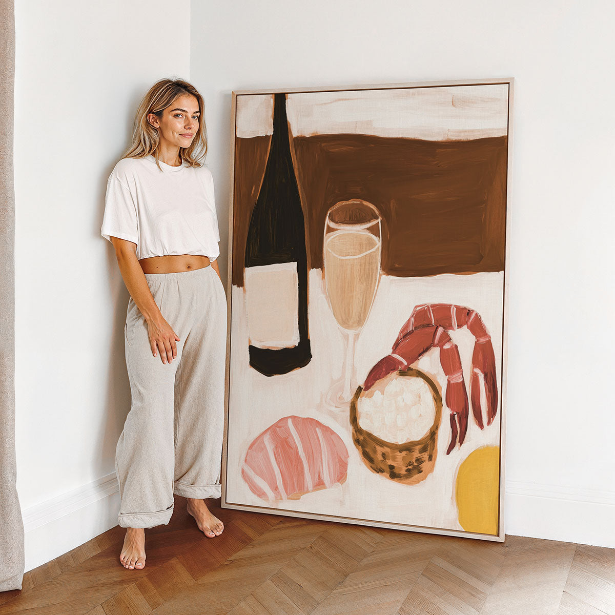 Woman standing next to a large abstract art canvas print on a wall in a kitchen.
