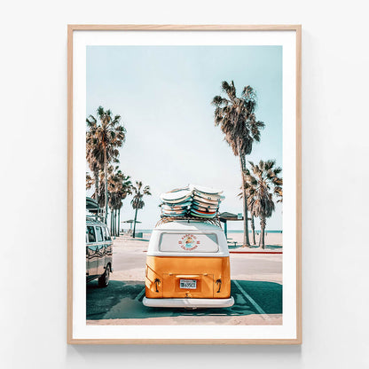 A framed photo wall art print featuring a surf van with surfboards by the beach
