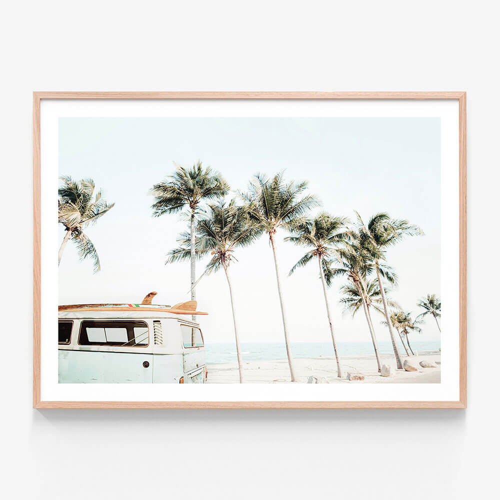 A framed coastal wall art print featuring palm trees and surf van.