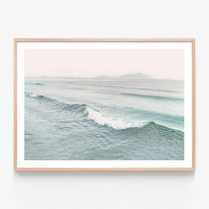 A framed photo wall art print featuring a coastal wave in pastel colours